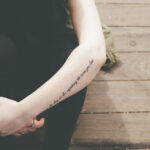 tattooed arms, hand-in-hand