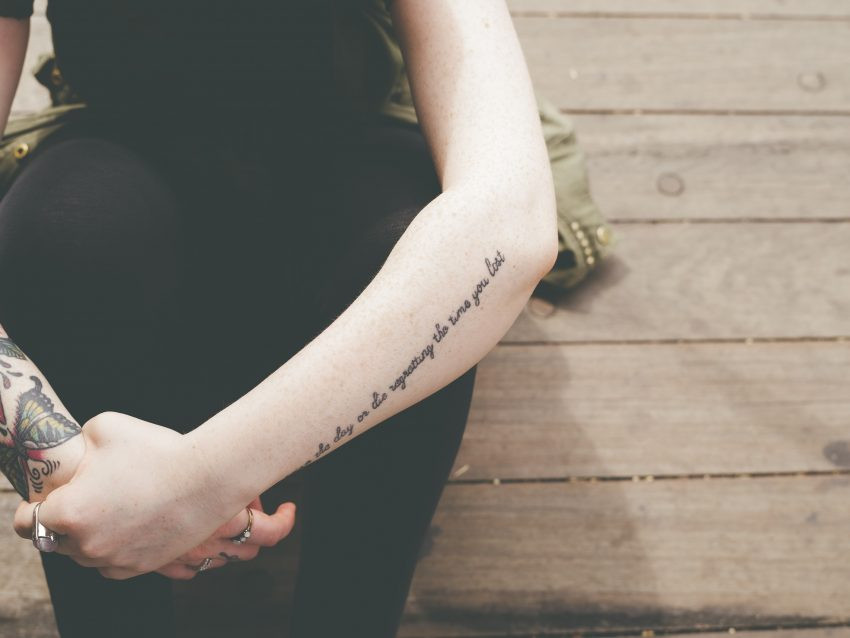 tattooed arms, hand-in-hand