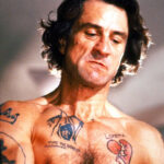 Robert De Niro as Max Cady in Cape Fear with prominent tattoos, showcasing the character's menacing persona and the impact of tattoos in cinematic storytelling.