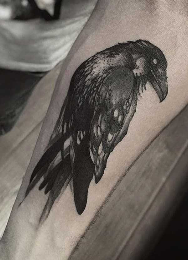 A crow tattoo design inspired by Norse mythology, featuring runes and symbols of Odin