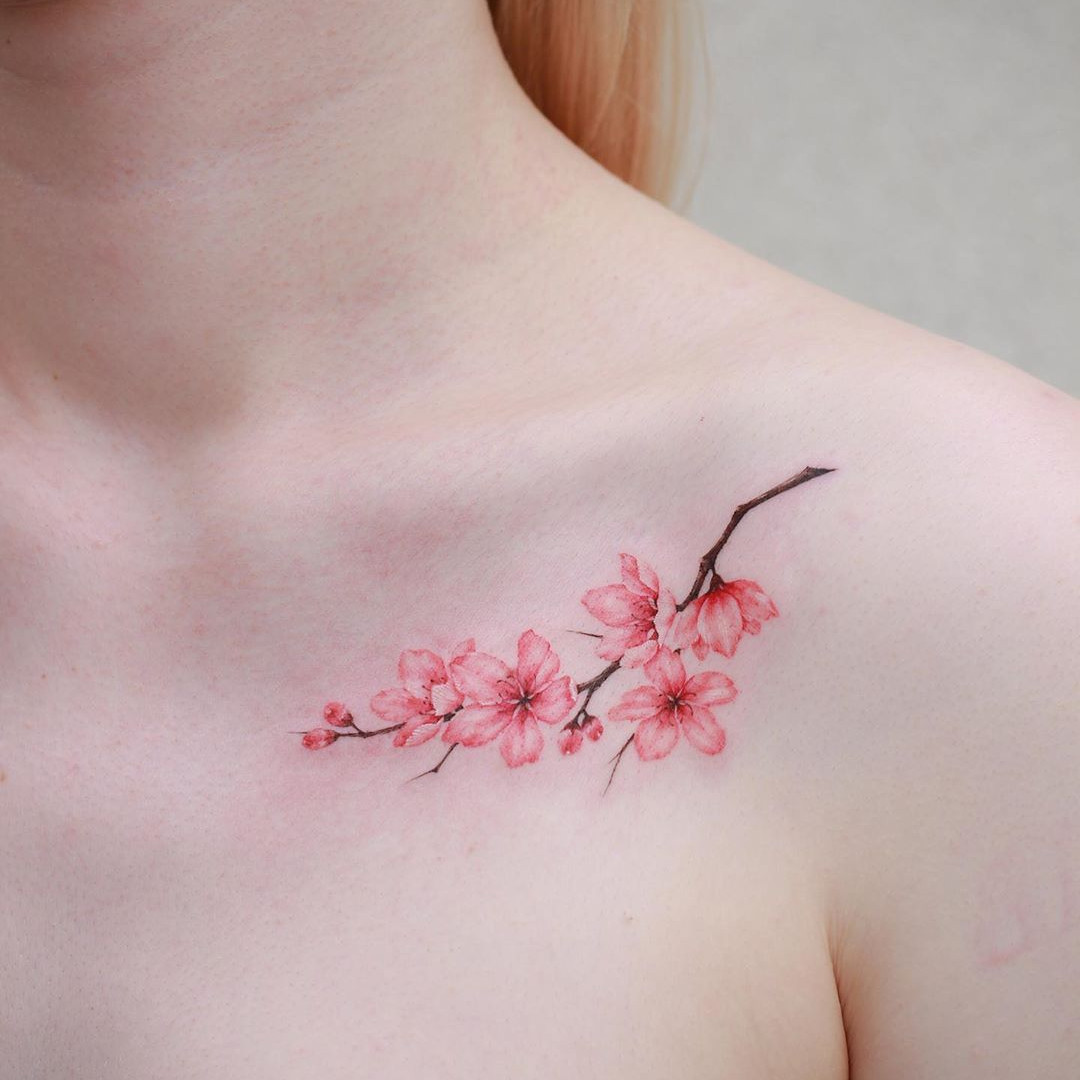 A stunning back piece featuring a vibrant Japanese cherry blossom tattoo with intricate details.
