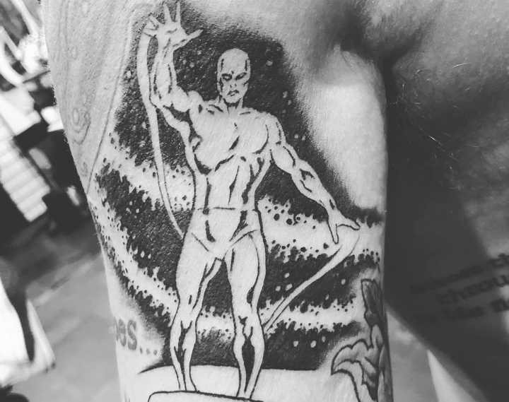Close-up of Titus Welliver's Silver Surfer tattoo with floral framing