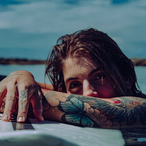 A person refraining from swimming to protect their new tattoo, emphasizing the importance of waiting for complete healing