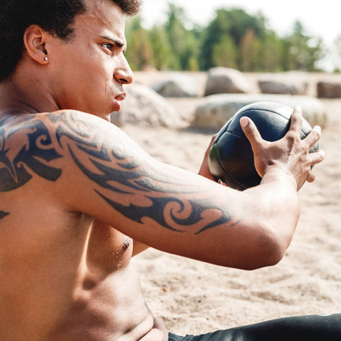 An individual performing a HIIT workout, taking care to avoid friction on their new tattoo