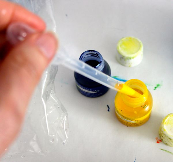 Hand holding a bottle of blue tattoo ink