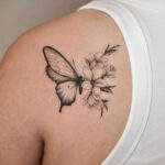 Elegant butterfly and flower ink design on the shoulder
