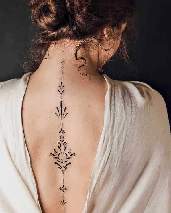 Elegant spine tattoo with an ornamental design, inked by @bibi.lea_.tattoo