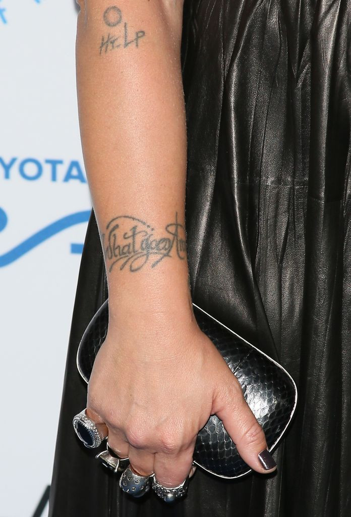 Pink's wrist tattoo, &quot;What goes around comes around&quot;, displaying a small, meaningful tattoo