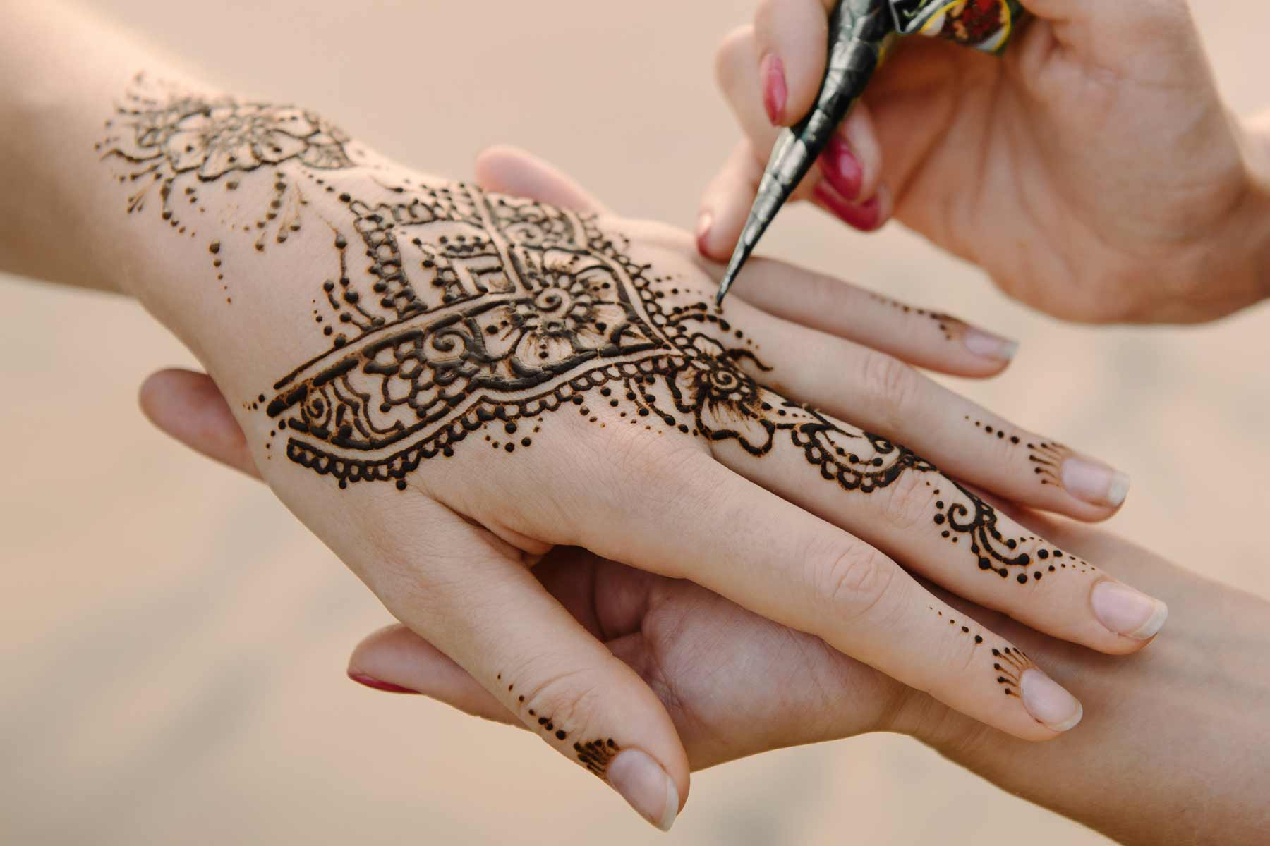 An artist applying henna to a woman