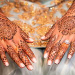A bride displaying henna art on her hands and arms.