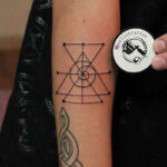 An intricate sigil tattoo design on an arm, showcasing the geometric linework characteristic of sigil tattoos
