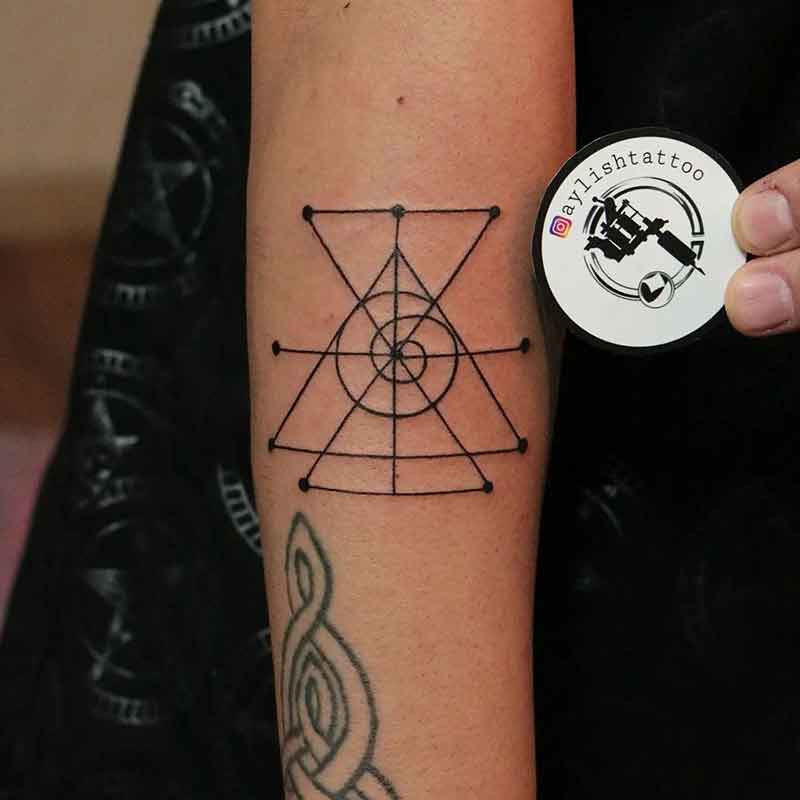 An intricate sigil tattoo design on an arm, showcasing the geometric linework characteristic of sigil tattoos