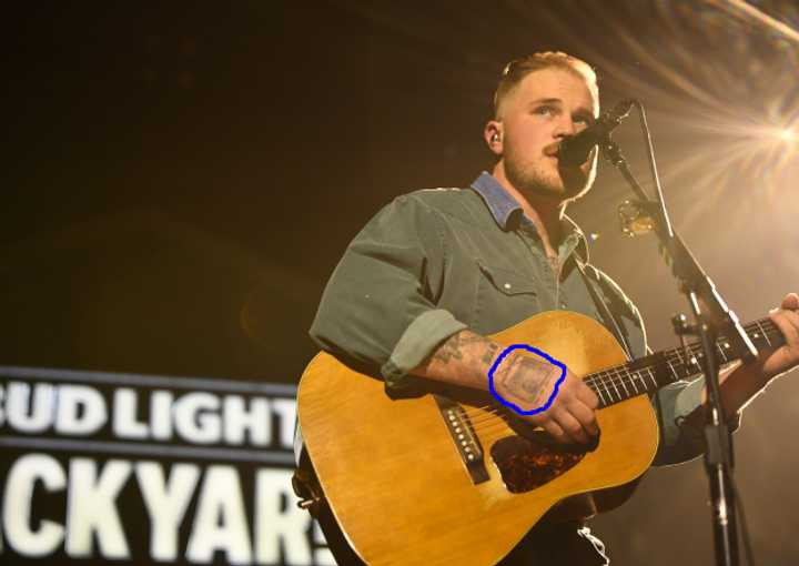 Zach Bryan performing at The Chelsea, showcasing his radio tattoo.