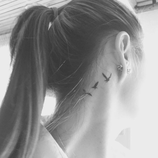 Feminine neck tattoo of bird silhouette