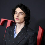 Finn Wolfhard's potential shoulder tattoo, as captured in a photoshoot, igniting fan speculation about his body art