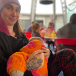 Fiona Lewitt breastfeeding her baby who is in an orange onesie