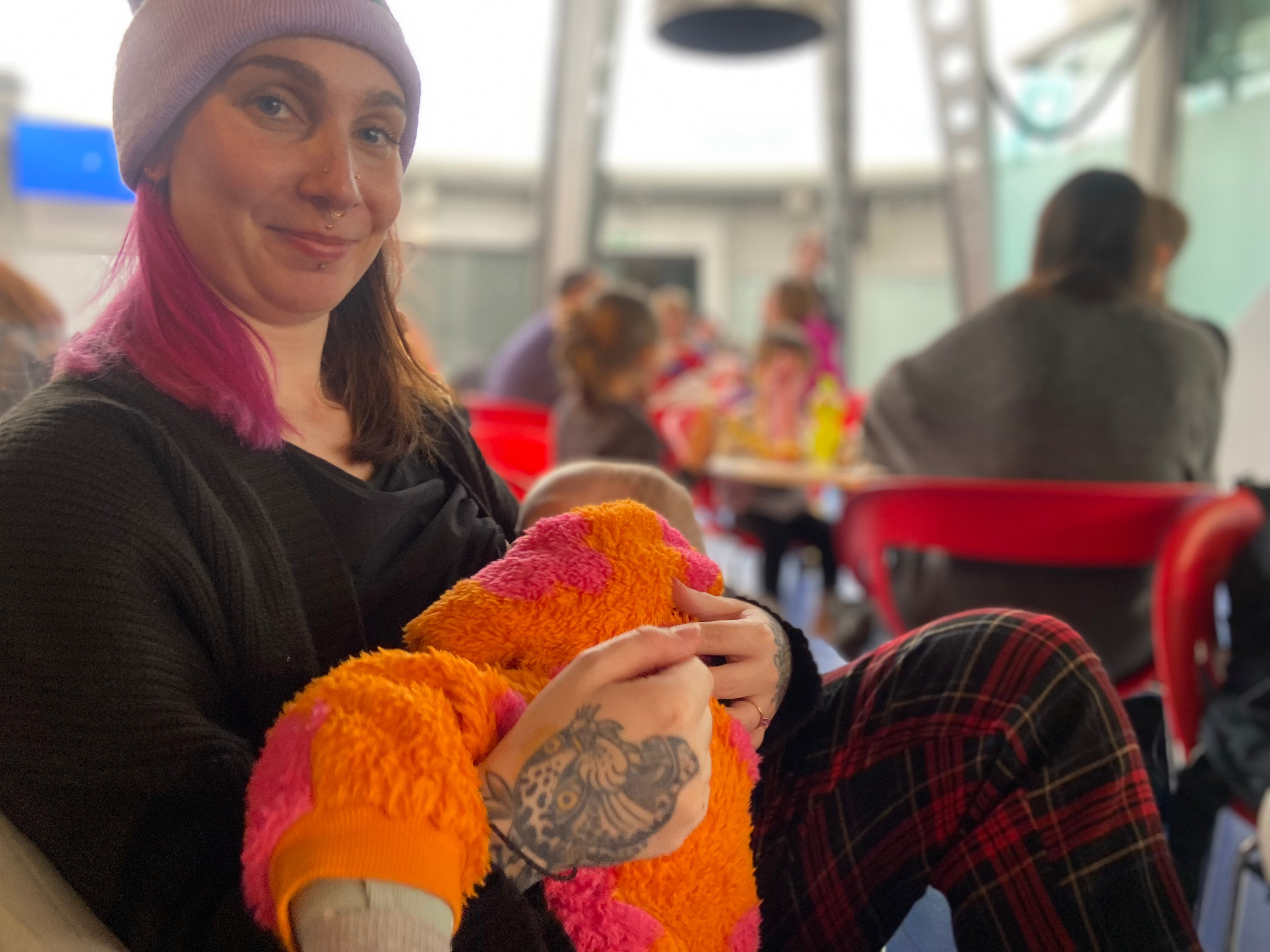 Fiona Lewitt breastfeeding her baby who is in an orange onesie