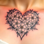 A stunning floral heart tattoo adorns the collarbone, featuring intricate linework and delicate white flowers, symbolizing love and beauty, perfect for romantic tattoo art inspiration.