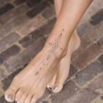A delicate floral foot tattoo