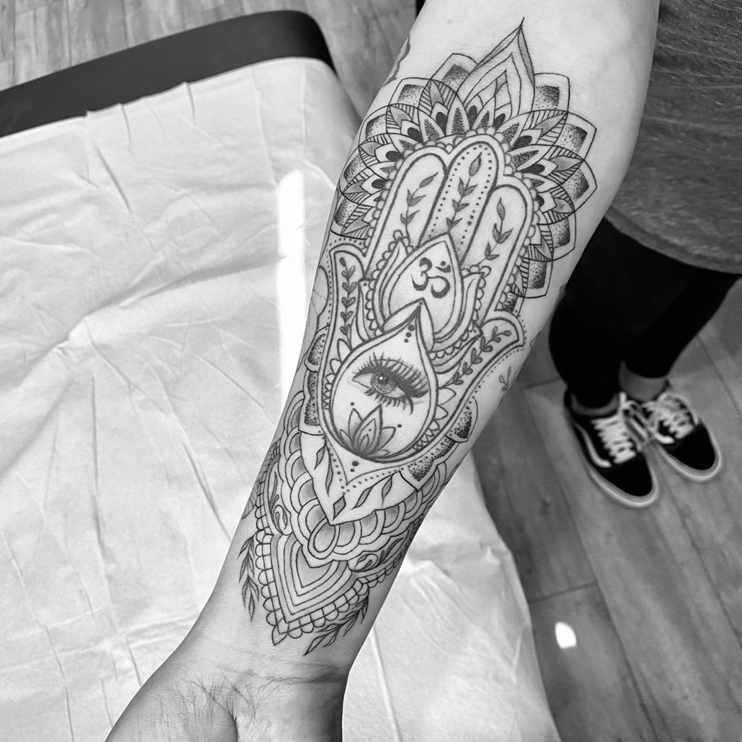 A traditional Hamsa tattoo design with bold lines and vibrant colors, demonstrating its use as a spiritual amulet