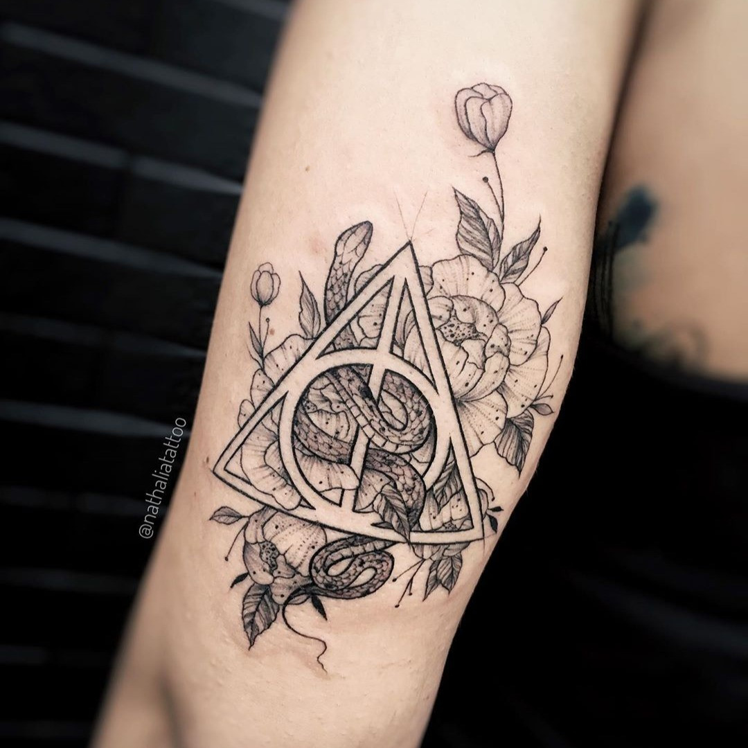 A finger tattoo of the Deathly Hallows symbol from the Harry Potter series.