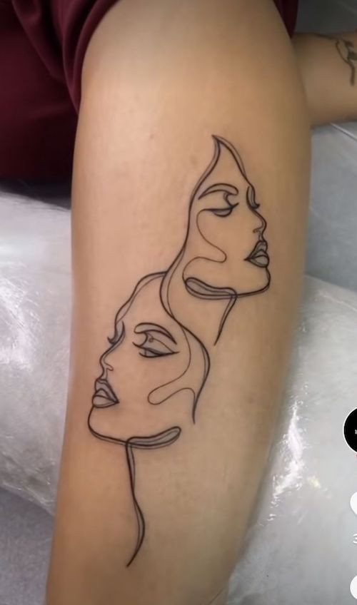Two faces with interconnected lines forming the Gemini symbol on the arm