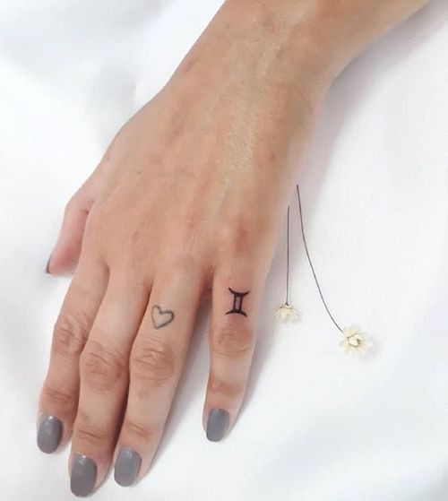 Black ink Gemini glyph tattoo on the upper arm