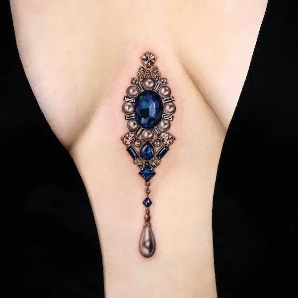 Gemstone pendant between the boobs creating the illusion of luxurious jewelry.