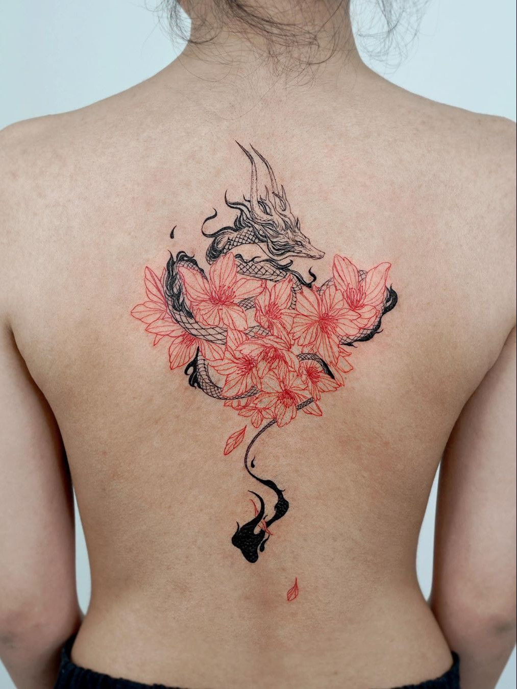 A simple and beautiful ankle tattoo featuring a few delicate Japanese cherry blossoms.