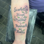 Floral vine tattoo with grandchildren's names, showcasing a delicate design with flowers and leaves intertwined with elegant script, symbolizing growth, family bonds, and individuality