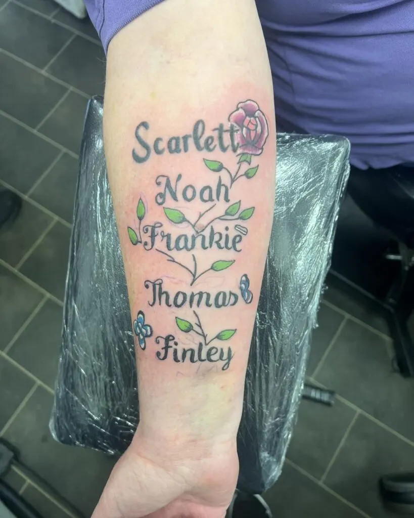 Floral vine tattoo with grandchildren's names, showcasing a delicate design with flowers and leaves intertwined with elegant script, symbolizing growth, family bonds, and individuality