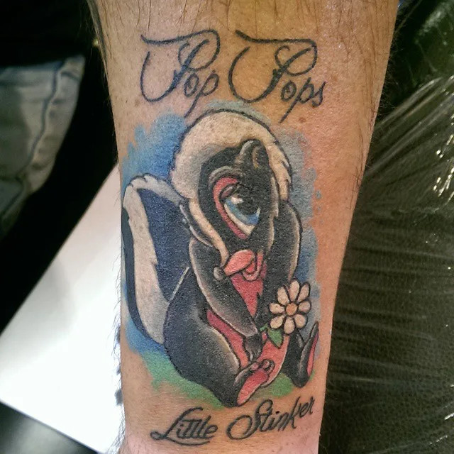 Cute skunk with grandparent nickname tattoo, reflecting a fun and loving relationship with a playful cartoon skunk and affectionate nicknames