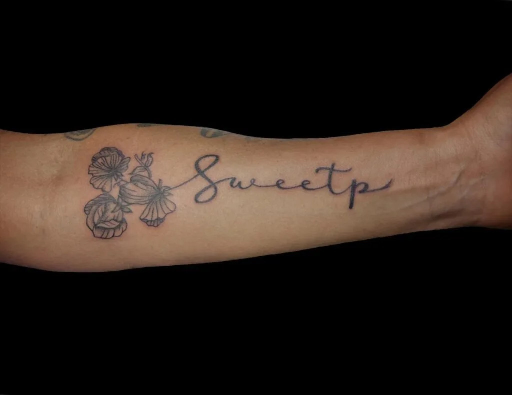 Sweet P with flowers tattoo, symbolizing love and endearment with an elegant script and intricate floral elements