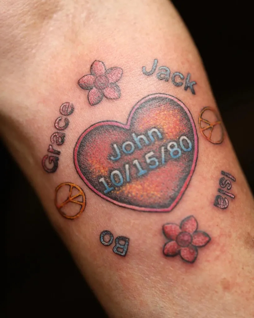 Heart with grandchildren's names and symbols tattoo, representing love, peace, and a special connection with colorful design elements