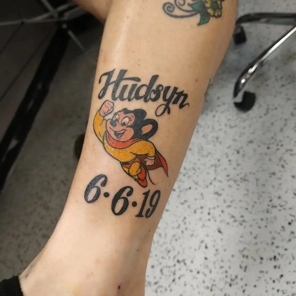 Superhero grandchild tattoo, a fun and vibrant design symbolizing admiration and pride with a cartoon superhero character, name, and birthdate