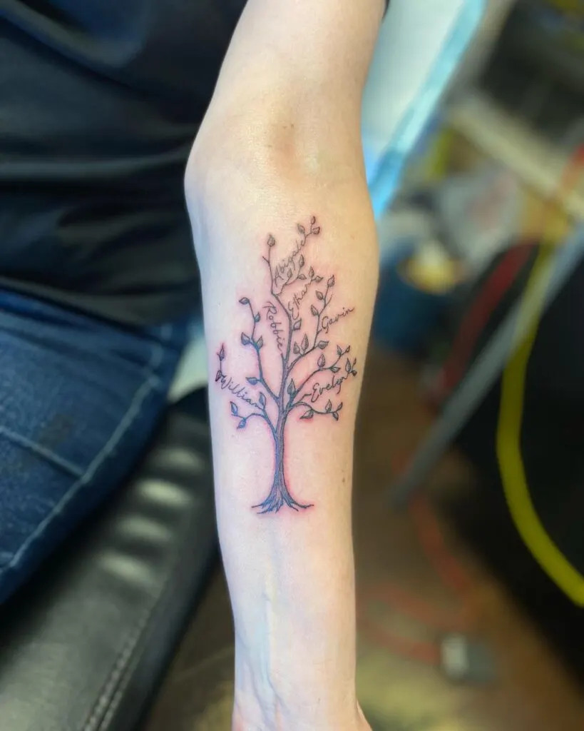 Family tree with names tattoo, symbolizing family growth and interconnectedness with a delicate tree design and carefully integrated names