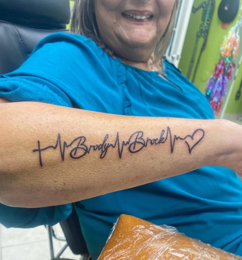 Heartbeat name tattoo, symbolizing love and importance with names intertwined with an EKG heartbeat line
