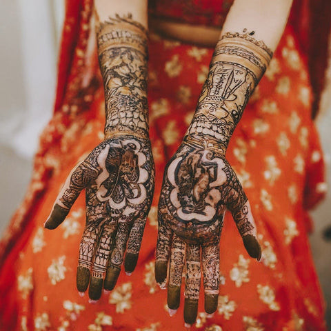 A bride with intricate henna designs on her hands for a wedding.