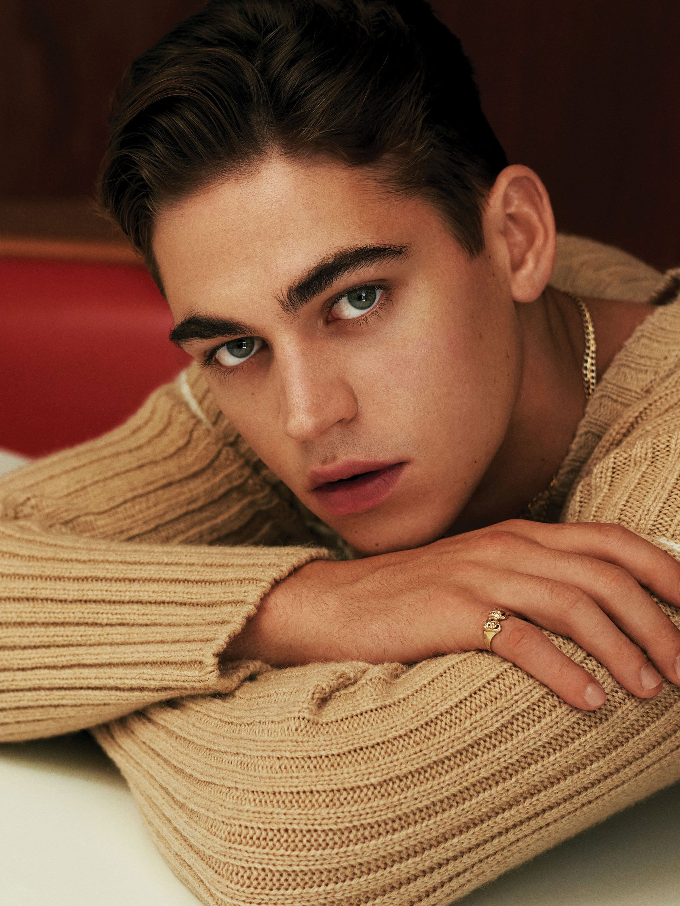 Hero Fiennes Tiffin showcasing a fashionable sweater, highlighting the textures and colors he incorporates into his attire