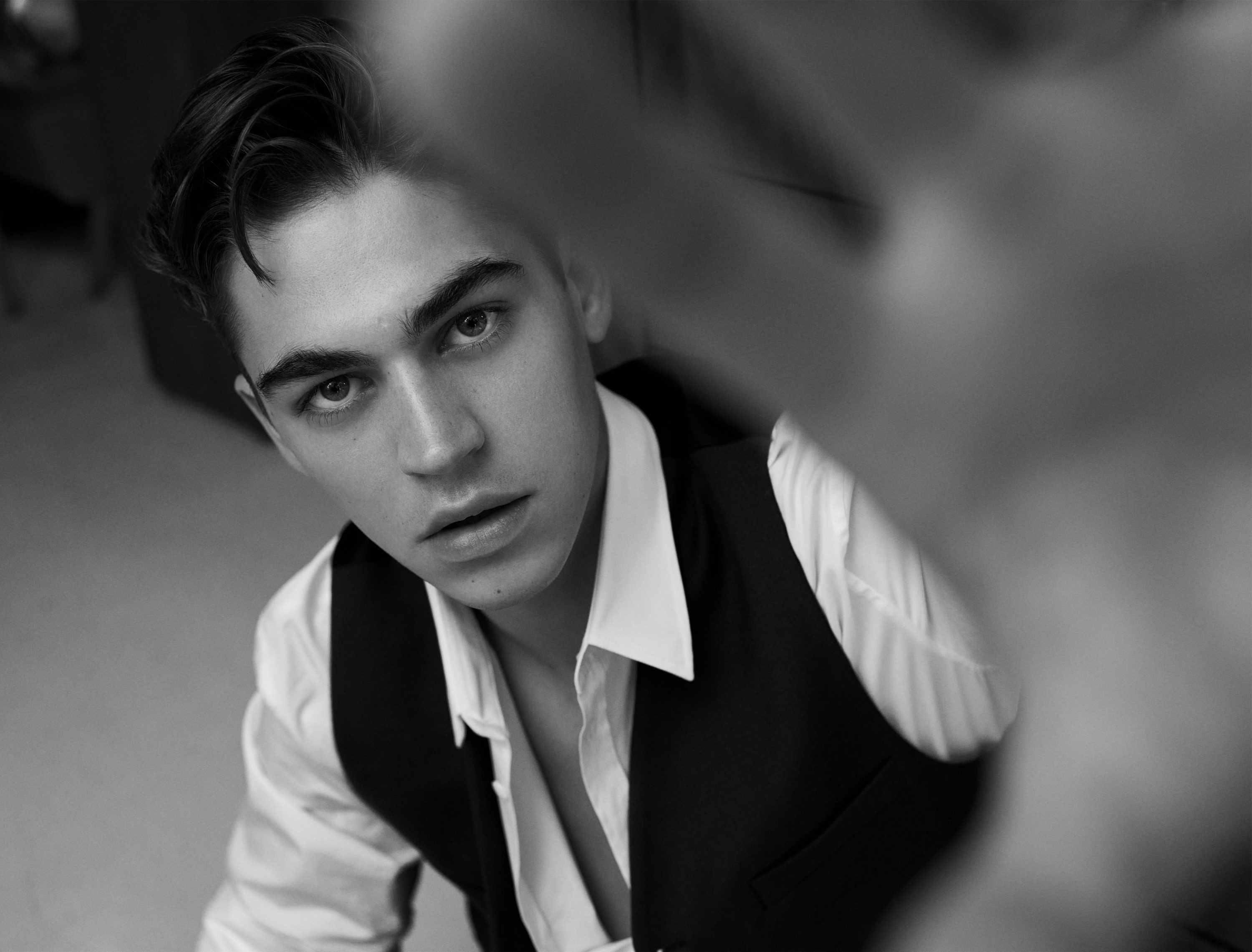 Hero Fiennes Tiffin in a black and white portrait, accentuating his natural features and understated style