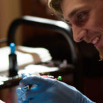 Tattoo artist disinfecting tattoo equipment with spray