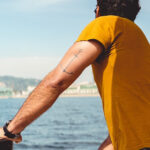 Fresh tattoo on arm healing, depicting the importance of waiting before saltwater exposure