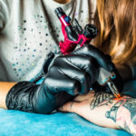 Tattoo artist applying stencil on skin
