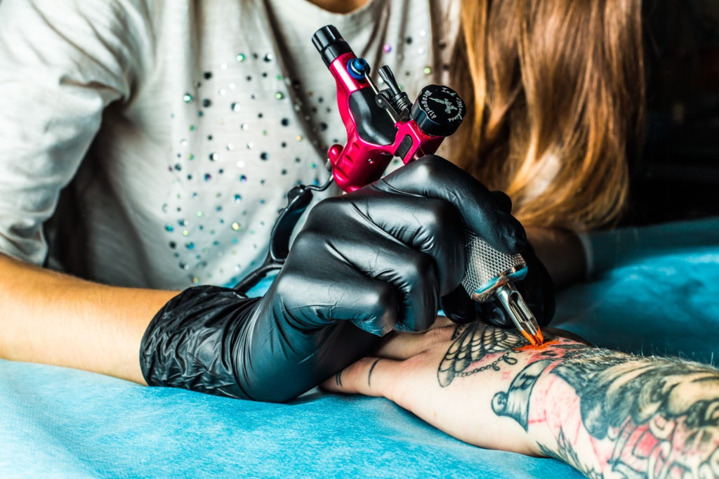 Tattoo artist applying stencil on skin