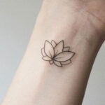 Delicate lotus flower wrist tattoo symbolizing purity and rebirth