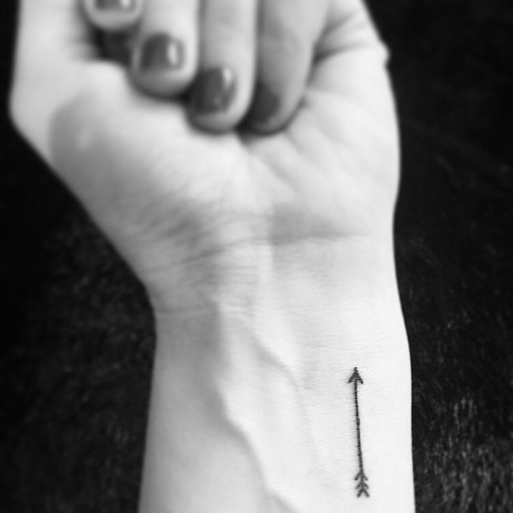 Minimalist arrow wrist tattoo representing direction and moving forward