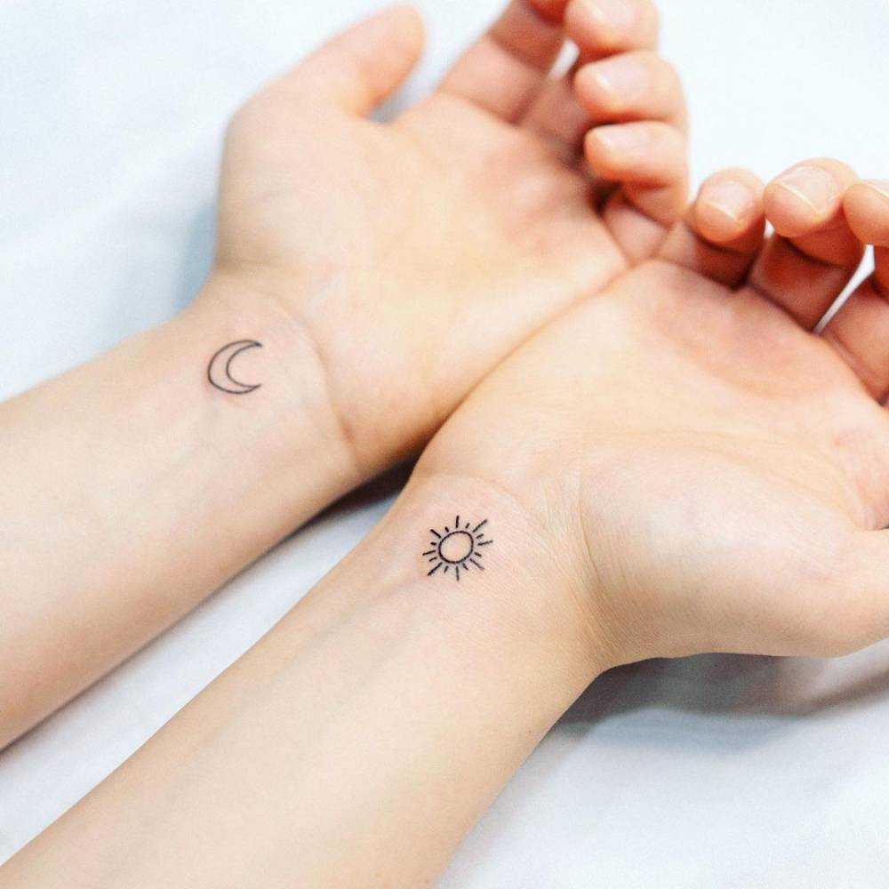 Sun and moon wrist tattoo representing balance and harmony