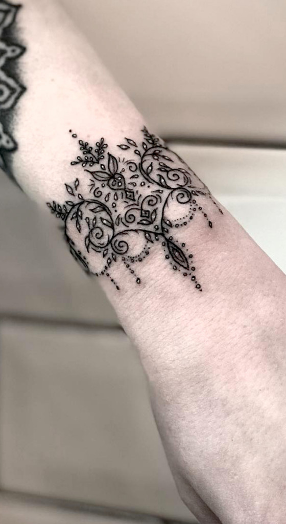 Lace pattern wrist tattoo offering a delicate and feminine design