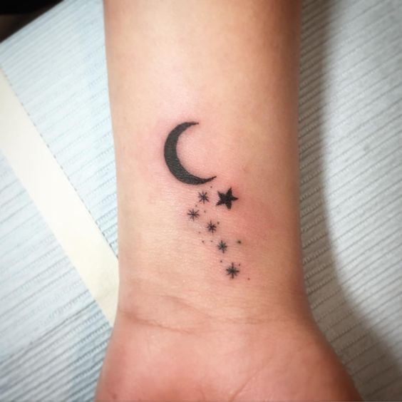 Moon with stars wrist tattoo combining celestial elements