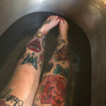 Tattooed legs in the bath tub after full recovery